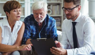 Retirees discuss their retirement plan with financial advisor in contemporary home