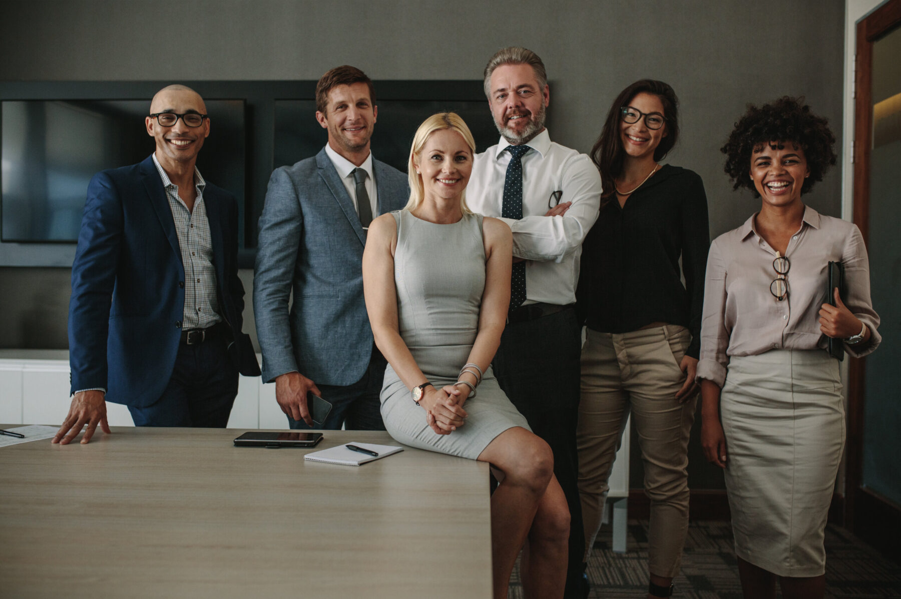 Posed image of C-suite executives of many races, ages, and genders in conference room