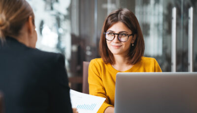 Professional financial planner listens to client during review of financial data