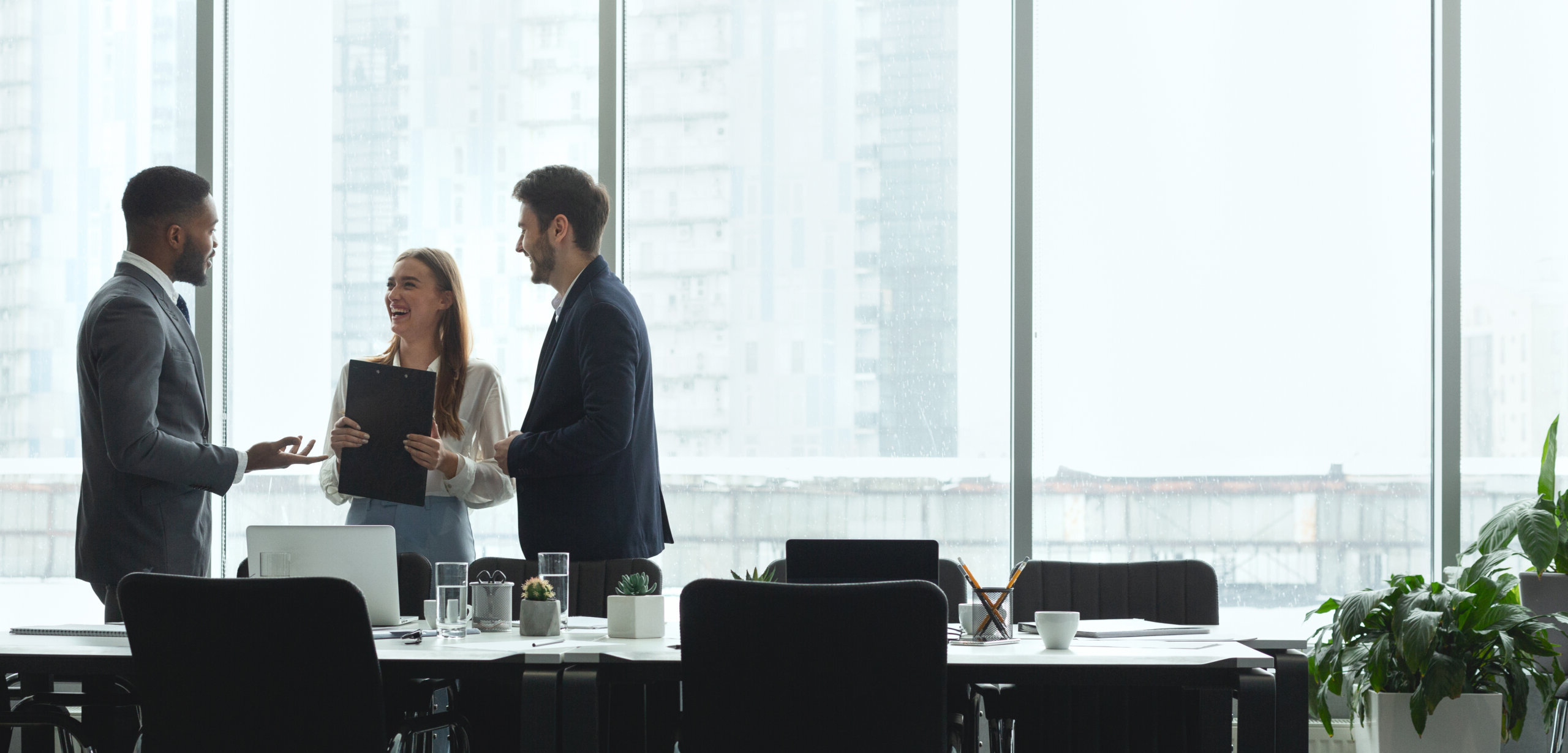 Professional business colleagues converse in modern conference room